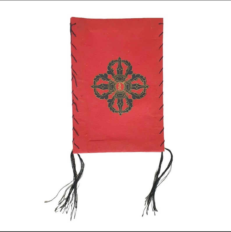 May include: A red leather-bound journal with black stitching and tassels. The cover features a black and gold mandala design.