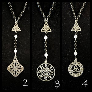 May include: Three black beaded necklaces with silver Celtic knot pendants. The first necklace has a simple triangular knot pendant. The second necklace has a square knot pendant. The third necklace has a circular knot pendant with a sunburst design.