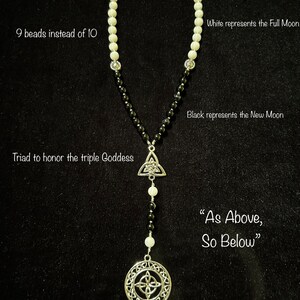 May include: A black and white beaded necklace with a silver Celtic knot pendant and a silver Celtic cross charm. The necklace has 9 white beads and 9 black beads. The text "As Above, So Below" is written below the pendant.