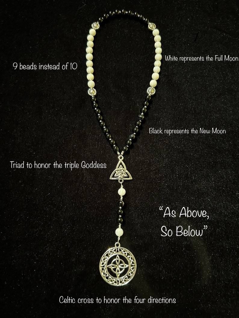 May include: A black and white beaded necklace with a silver Celtic knot pendant and a silver Celtic cross charm. The necklace has 9 white beads and 9 black beads. The text "As Above, So Below" is written below the pendant.