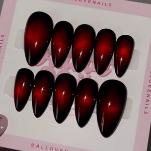 May include: Set of ten oval-shaped false nails with a gradient design. The nails transition from a deep red at the base to black at the tips. The brand name "ALLOVENAILS" is printed on the packaging.