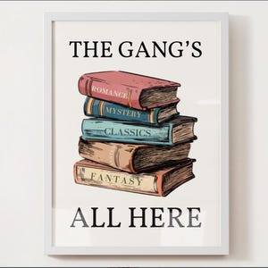 May include: A white framed print with the text "The Gang's All Here" in black. The print features a stack of five books with different colored covers and the words "Romance", "Mystery", "Classics", and "Fantasy" written on them.