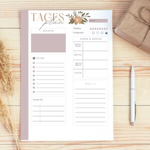 May include: A printable daily planner with sections for important tasks, to-do list, appointments, meals, and mood tracking. The planner has a floral design with a light brown and pink color scheme.