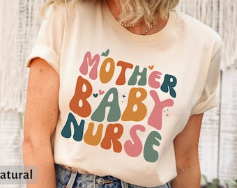 May include: A beige t-shirt with a colorful graphic that says "Mother Baby Nurse" in a retro font. The graphic features hearts, stars, and butterflies.