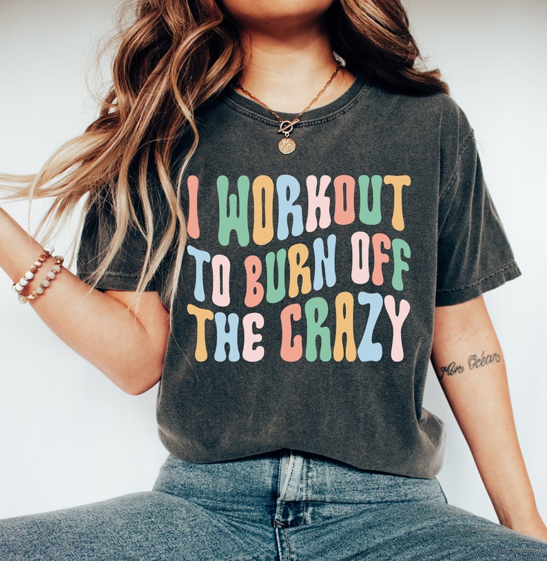 May include: A black t-shirt with the text "I workout to burn off the crazy" in colorful, outlined letters. The text is in a retro font style.