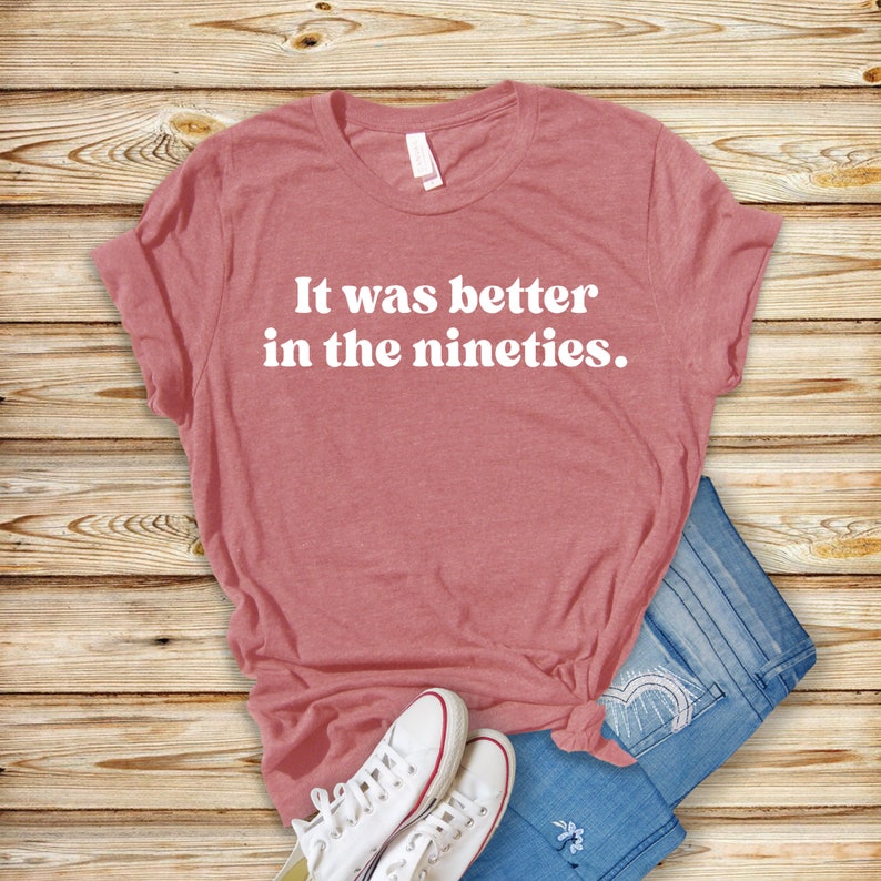 Może przedstawiać: R&oacute;żowy T-shirt z nadrukiem "It was better in the nineties." w kolorze białym.