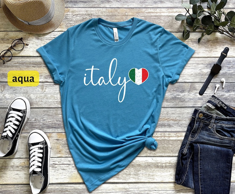 May include: Aqua blue t-shirt with the word "italy" in white script and a heart-shaped Italian flag graphic.