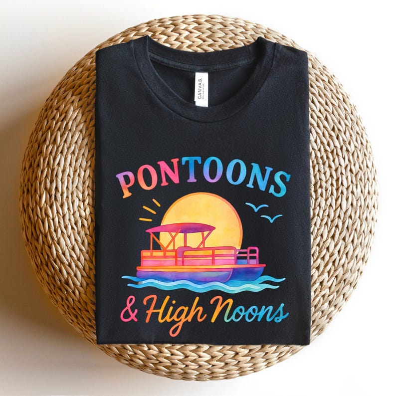 May include: Black t-shirt featuring a colorful graphic of a pontoon boat on water with a sunset and the words "Pontoons & High Noons". The design is in shades of orange, pink, blue, and yellow.