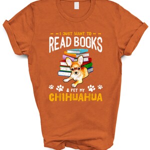 May include: Orange t-shirt with a graphic of a chihuahua sitting on a stack of books. The text on the shirt reads "I just want to read books & pet my chihuahua".