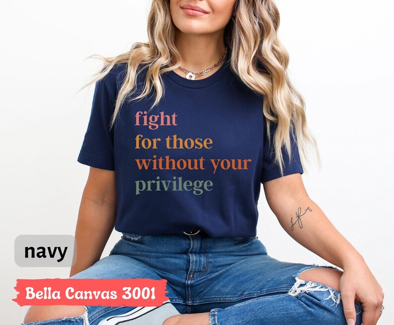 Op de afbeelding: Navyblauw Bella Canvas 3001 T-shirt met de tekst "fight for those without your privilege" gedrukt in regenboogkleuren.