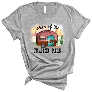 May include: Gray t-shirt with a graphic of a vintage camper in a desert landscape. The text "Queen of the Trailer Park" is printed below the camper.