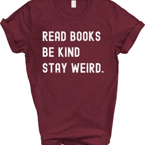 May include: Burgundy t-shirt with white text that reads "Read Books Be Kind Stay Weird."