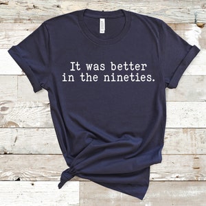 K&ouml;nnte beinhalten: Ein marineblaues T-Shirt mit wei&szlig;em Text, der "Es war besser in den Neunzigern." lautet.