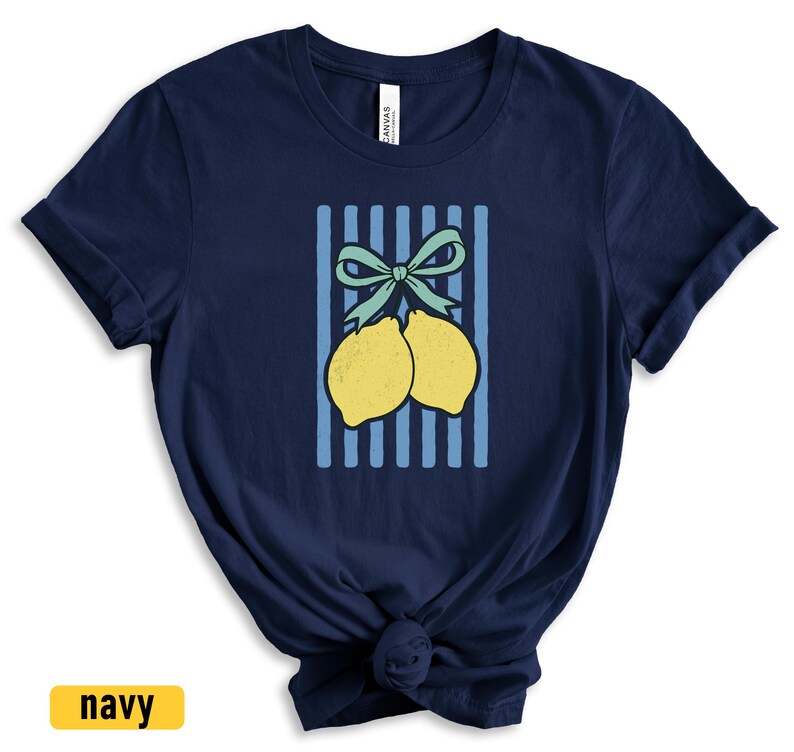 May include: A navy blue t-shirt with a graphic of two lemons tied together with a green bow on a blue and white striped background.