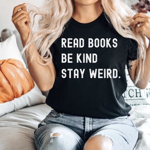 May include: A black t-shirt with white text that reads "Read Books Be Kind Stay Weird."