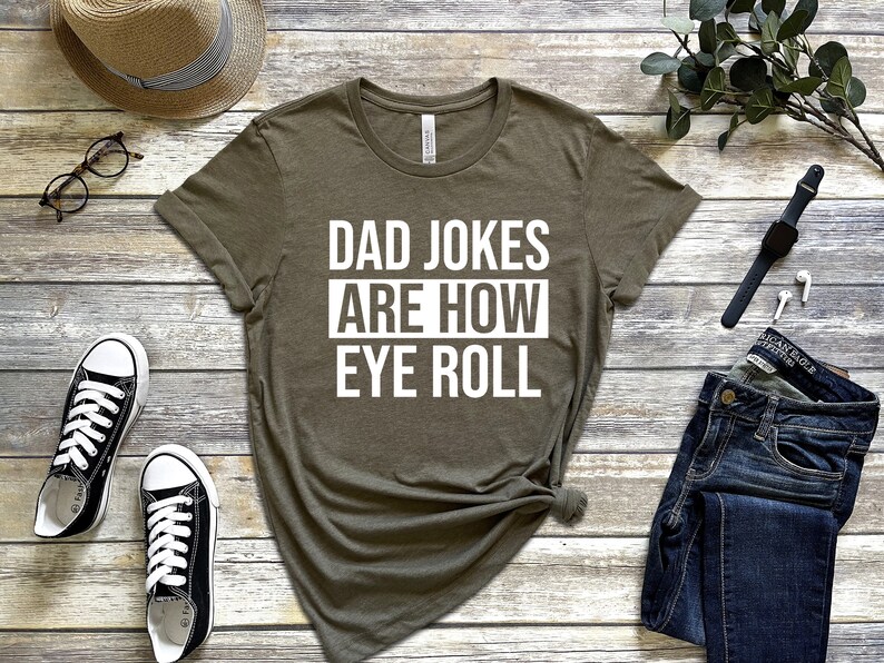 May include: A green t-shirt with white text that reads "Dad Jokes Are How Eye Roll".