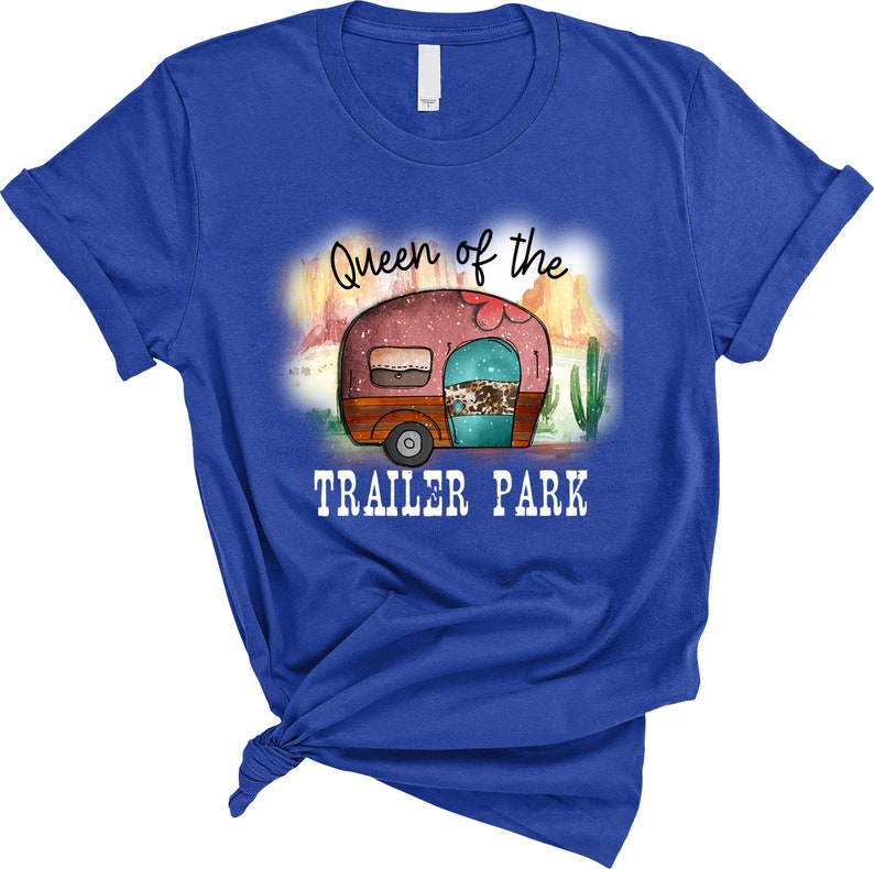 May include: A royal blue t-shirt with the text "Queen of the Trailer Park" and a watercolor illustration of a vintage camper in a desert landscape.