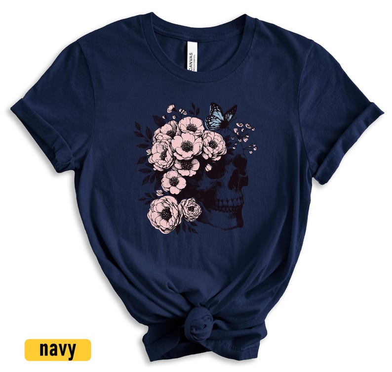 May include: A navy blue t-shirt with a graphic of a skull with pink flowers and a blue butterfly.