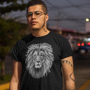 Może przedstawiać: Czarny t-shirt z grafiką głowy lwa w czerni i bieli. Lew ma pełną grzywę i patrzy bezpośrednio na widza.