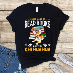 May include: Black t-shirt with a chihuahua sitting on a stack of books. The text on the shirt reads "I just want to read books & pet my chihuahua".