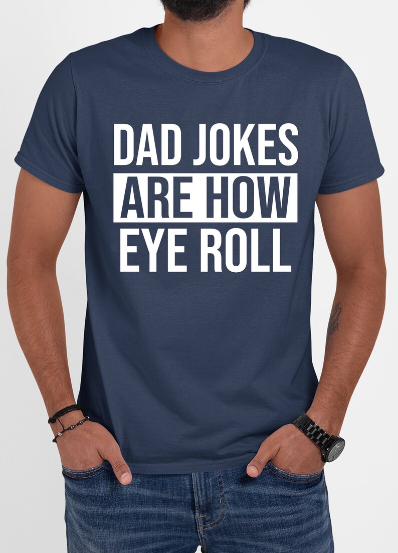 May include: A navy blue t-shirt with white text that reads "Dad Jokes Are How Eye Roll".