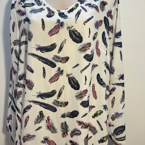 Preloved second hand off white long blouse shaped as a tunic with colored feathers in black pink and purple
