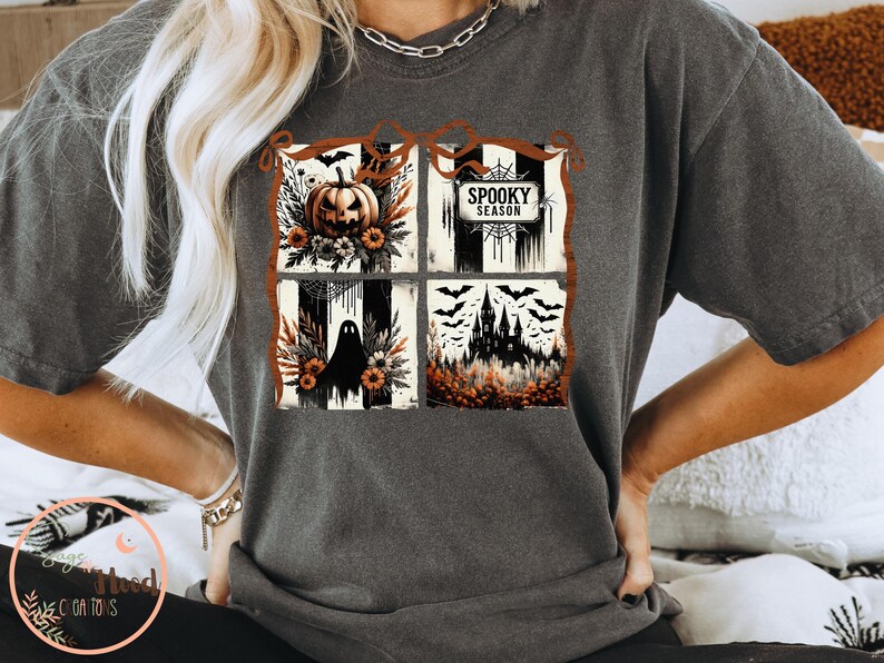 May include: Dark gray t-shirt featuring a four-panel Halloween design. The panels include a jack-o'-lantern, the text "Spooky Season", a ghost, and a haunted castle. The design incorporates black, orange, and white elements.