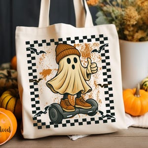 May include: Cream tote bag with a cartoon ghost on a hoverboard, wearing a beanie and trainers, giving a thumbs-up. The design includes bats and a chequered border, with a distressed orange background. Ideal for Halloween.
