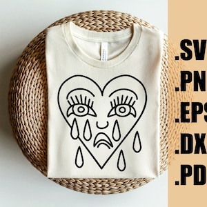Puede incluir: Una camiseta blanca con un contorno negro de un corazón llorando con pestañas y lágrimas. El corazón tiene una pequeña sonrisa.
