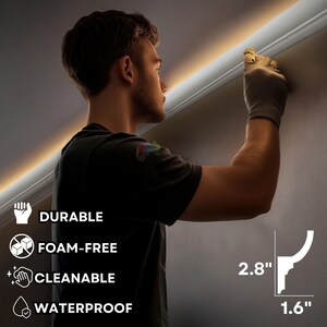 May include: A person installing white crown molding. The molding is 2.8 inches high and 1.6 inches wide. The image includes icons indicating the molding is durable, foam-free, cleanable, and waterproof.