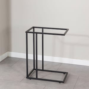 May include: A black metal side table with a rectangular top and a C-shaped design. The table has a minimalist style and is suitable for various home decor styles. The table is made of metal.