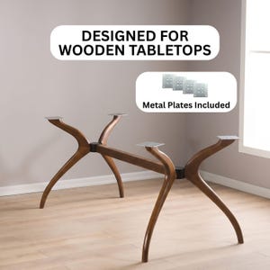 May include: A dark brown wooden table base with four curved legs and a central support beam. The text "DESIGNED FOR WOODEN TABLETOPS" and "Metal Plates Included" appears above the base, along with an image of four square metal plates.