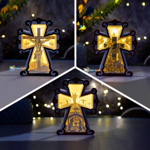 Może przedstawiać: Trzy podświetlane drewniane dekoracje w kształcie krzyża z różnymi scenami religijnymi. Pierwszy krzyż przedstawia Jezusa na krzyżu, drugi krzyż przedstawia gołębia i kwiaty, a trzeci krzyż przedstawia scenę narodzin.