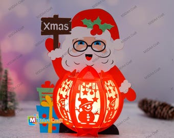 May include: A red and white Christmas lantern with a snowman design. The lantern is held by a Santa Claus figure with a sign that says "Xmas".