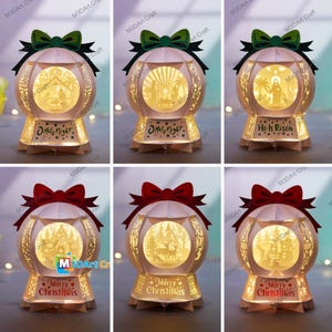 Può includere: Una collezione di ornamenti natalizi di carta illuminati. Ogni ornamento presenta un design dettagliato e stratificato con una scena festosa all'interno. Gli ornamenti sono adornati con fiocchi e testo che recita "Holy Night", "He Is Risen" e "Merry Christmas".