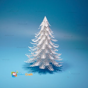 Peut inclure: Un arbre de No&euml;l en papier blanc avec des d&eacute;tails complexes, sur un fond bleu clair. L'arbre est fait de papier en couches et a un effet 3D. L'image comprend le texte "M3DArt Craft".