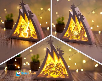 Può includere: Un presepe di Natale in legno con una luce all'interno. La scena rappresenta la sacra famiglia, una stella e animali. La scena ha una forma triangolare ed è illuminata dall'interno.