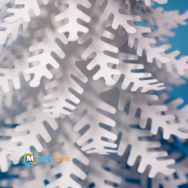 Peut inclure: Gros plan sur une d&eacute;coration de flocon de neige en papier blanc avec des d&eacute;tails complexes. Le flocon de neige est compos&eacute; de plusieurs couches de papier, cr&eacute;ant un effet 3D. Le flocon de neige est sur un fond bleu.