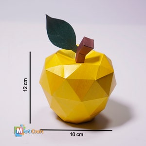 K&ouml;nnte beinhalten: Ein gelber Papier-Apfel mit einem gr&uuml;nen Blatt und einem braunen Stiel. Der Apfel ist 12 cm hoch und 10 cm breit.