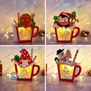 K&ouml;nnte beinhalten: Vier Weihnachts-Tassen aus Holz mit Beleuchtung. Jede Tasse zeigt eine andere Weihnachtsfigur: einen Lebkuchenmann, einen Pinguin, einen Schneemann und einen Kobold. Die Tassen sind alle rot und wei&szlig; mit aufwendigen Details.