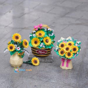 Peut inclure: Ensemble de trois mugs en céramique avec un glaçage moucheté de couleur crème. Chaque mug présente un motif peint à la main différent : une feuille bleue et verte, une fleur jaune et une baie rouge. Les mugs ont une forme simple et arrondie.