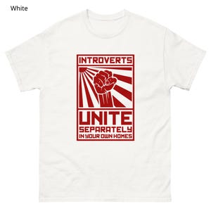 May include: White t-shirt with a red graphic. The graphic features the word "INTROVERTS" above a clenched fist, sun rays, and the word "UNITE" with the phrase "SEPARATELY IN YOUR OWN HOMES" below.