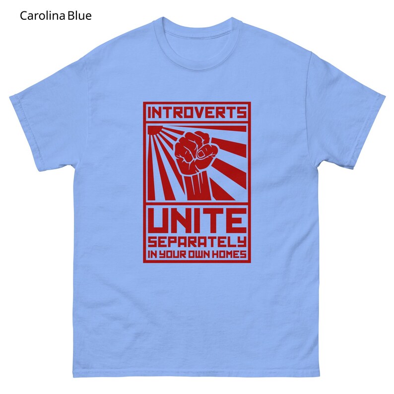 May include: Carolina blue t-shirt with a red graphic. The graphic features the word "INTROVERTS" above a clenched fist and the word "UNITE" with the phrase "SEPARATELY IN YOUR OWN HOMES" below.
