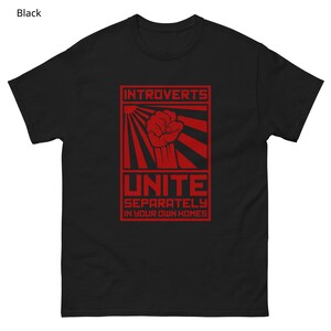 May include: Black t-shirt with a red graphic. The graphic features the word "INTROVERTS" above a red fist, with the word "UNITE" below. The text "SEPARATELY IN YOUR OWN HOMES" is at the bottom of the graphic.