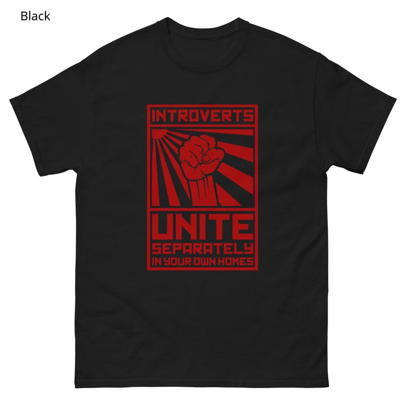 May include: Black t-shirt with a red graphic. The graphic features the word "INTROVERTS" above a red fist, with the word "UNITE" below. The text "SEPARATELY IN YOUR OWN HOMES" is at the bottom of the graphic.