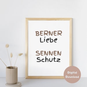 Könnte beinhalten: Ein gerahmter Druck mit dem Text "Berner Liebe Sennen Schutz" in brauner und schwarzer Schrift auf weißem Hintergrund. Der Rahmen ist aus hellem Holz.