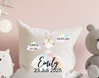 May include: A light-colored square pillow featuring a watercolor illustration of a princess with a crown and a rainbow-colored dress. The pillow includes the name "Emily" and the date "23. Juli 2025", along with weight and length measurements.