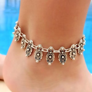 Close-up of silver plated brass adjustable anklet with authentic pattern and bead accents in antique finish.