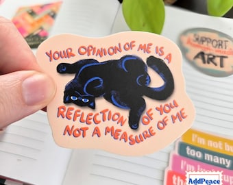 May include: A die-cut sticker with a light peach background featuring a black cat lying on its back with blue highlights. The text reads: YOUR OPINION OF ME IS A REFLECTION OF YOU NOT A MEASURE OF ME in orange lettering surrounding the cat illustration.