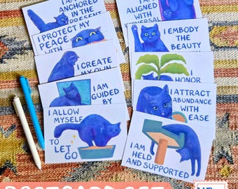 May include: A set of postcards featuring blue cat illustrations with affirmations including I am anchored in the present, I protect my peace, I create my own, I am guided by, I allow myself to let go, I am aligned with universal, I embody the beauty, I honor, I attract abundance with ease, and I am held and supported.